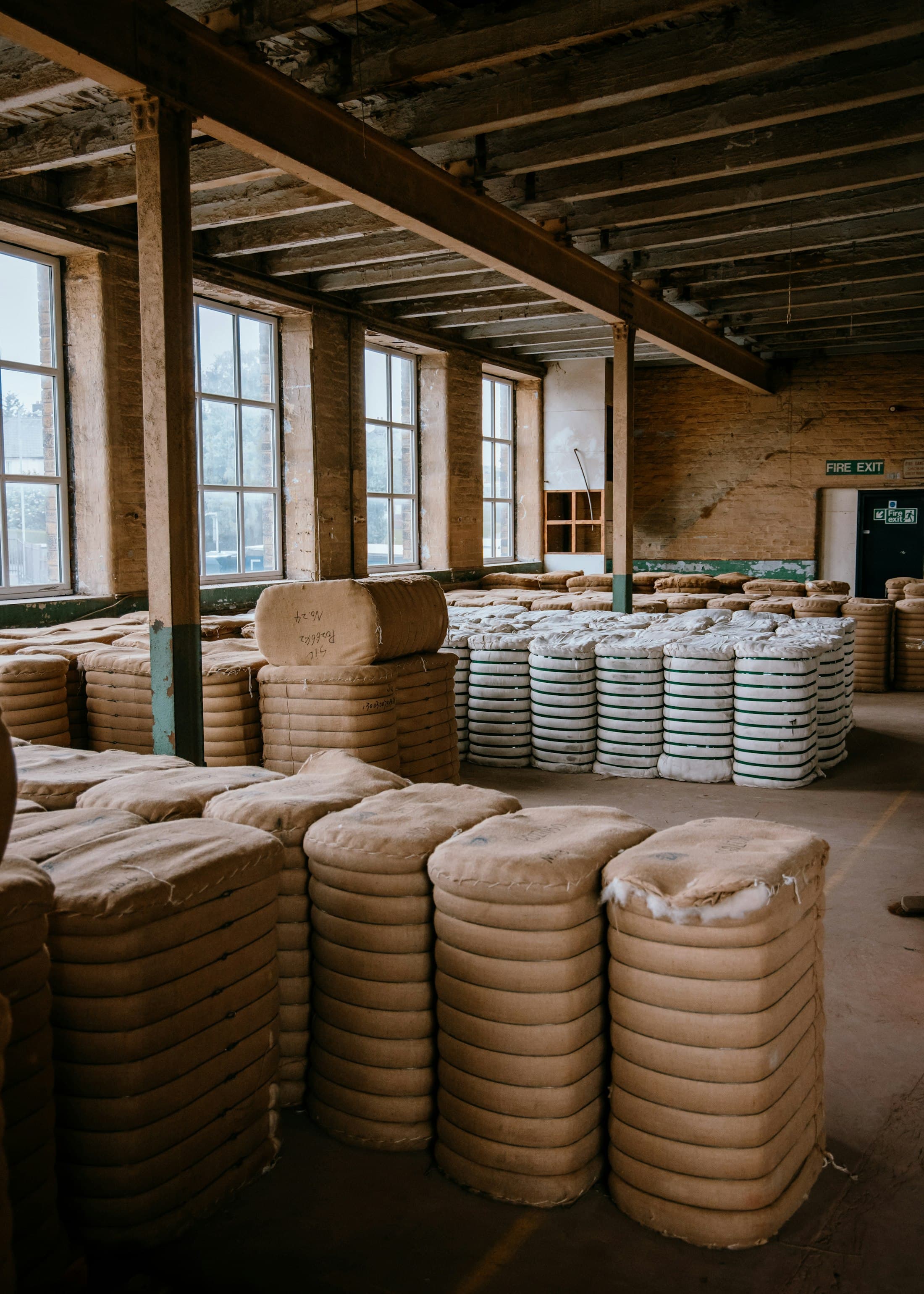 Compressed bales wrapped and stacked in columns in a mill store