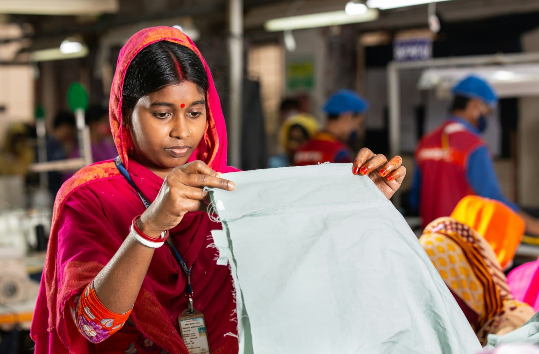 Operator inspecting cloth on the roll for weaving faults